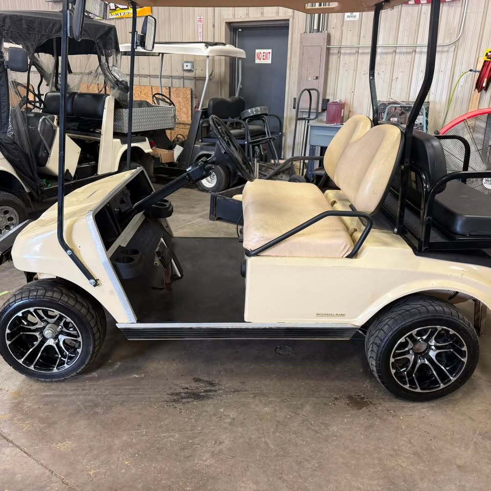 Golf cart on the shop floor getting new wheels installed